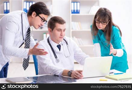 Three doctors discussing scan results of x-ray image. The three doctors discussing scan results of x-ray image