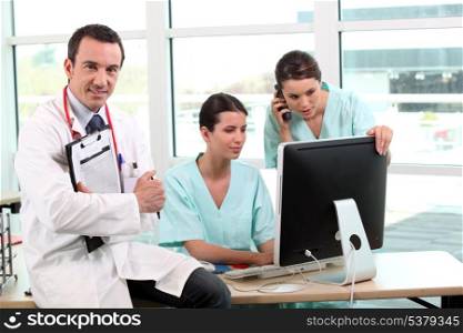 Three doctors gathered around desk