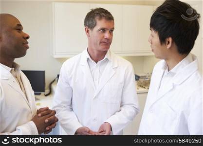 Three Doctors Having Discussion In American Hospital