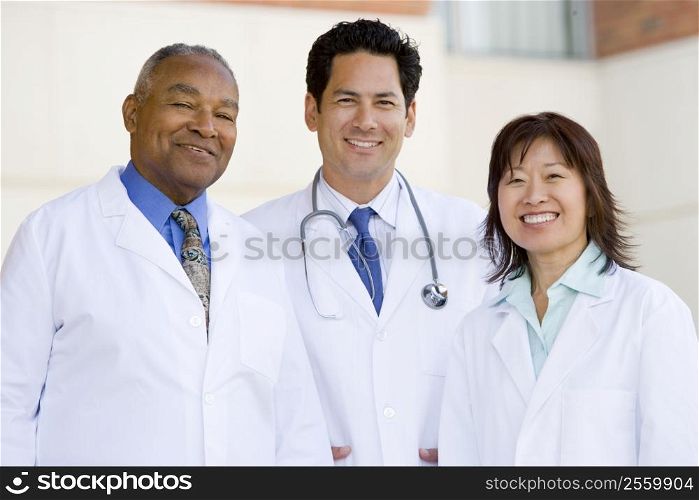Three Doctors Standing Outside A Hospital