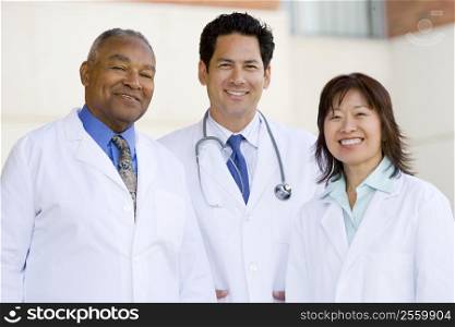 Three Doctors Standing Outside A Hospital