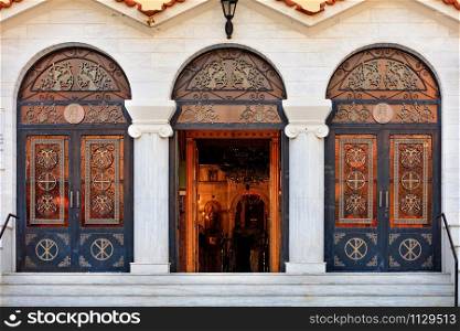 Three doors of the Ekklisia Agios Ioannis Orthodox Church in Loutraki, the middle door is open, August 15, 2019, Greece. Greece. Christian Church of St. John in Loutraki, August 15, 2019, Greece.