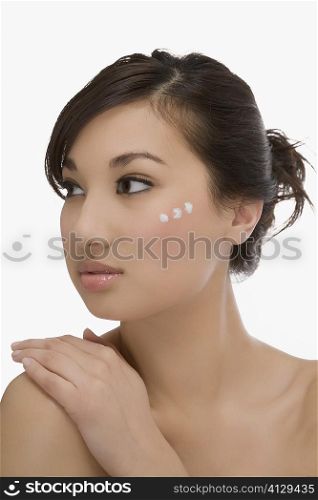 Three dots of moisturizer cream on a woman&acute;s face