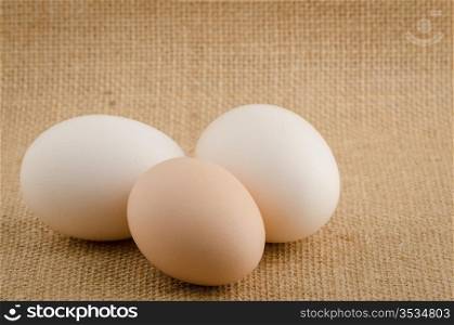 Three eggs on a raffia cloth background.