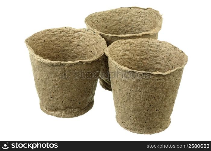 Three empty peat pots over white background