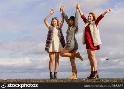 Three fashionable women having presenting pretty stylish outfits. Style, fashion, friendship concept.. Three fashionable woman outdoor