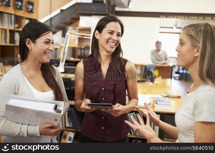 Three Female Architects Chatting In Modern Office Together