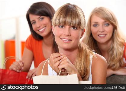 three female friends at home with shopping bags