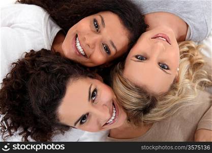 Three female friends laying down together