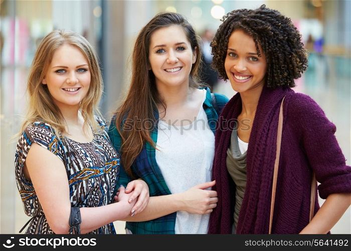 Three Female Friends Shopping In Mall Together