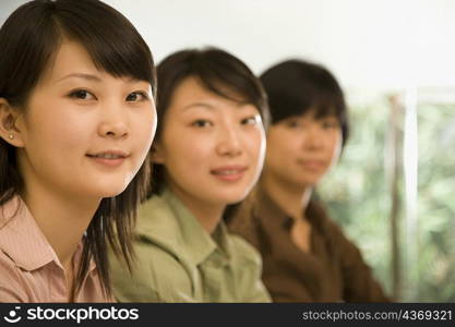 Three female office workers smiling