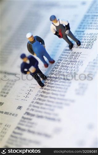 Three figurines on financial data
