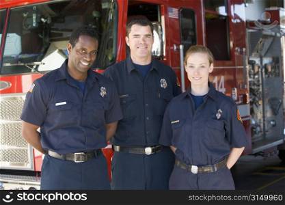 Three firefighters standing in front of fire engine