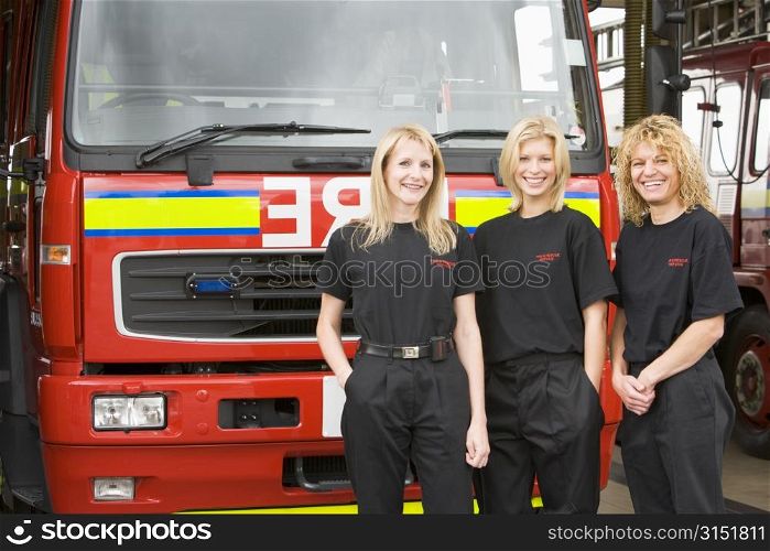 Three firefighters standing in front of fire engine