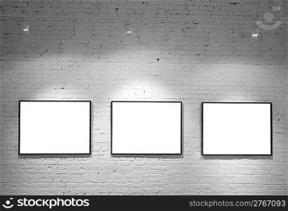 three frames on brick white wall