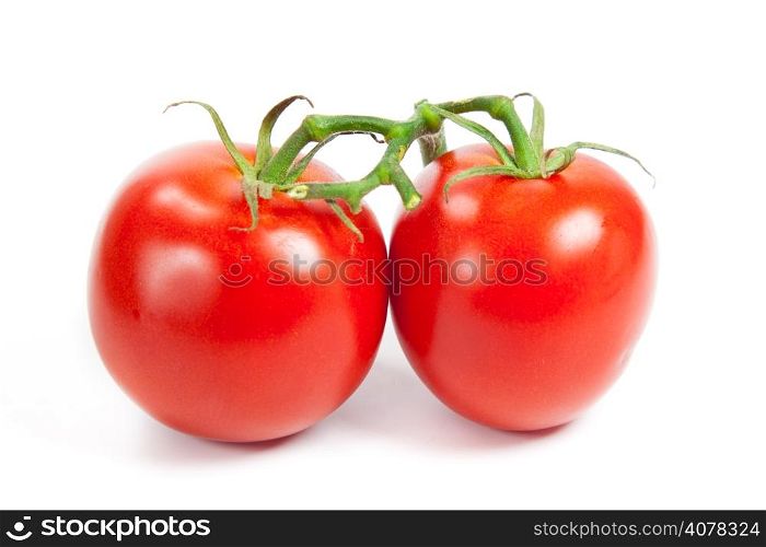 three fresh tomatoes with green leaves isolated on white background