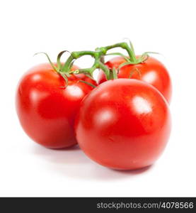 three fresh tomatoes with green leaves isolated on white background