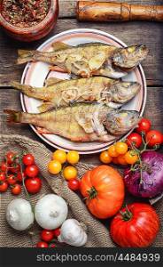 Three fried perch. Dish of fried perch and vegetables on rustic recipe