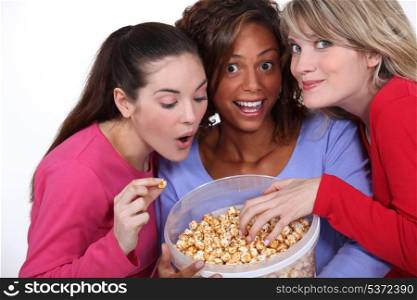 three friends eating popcorn