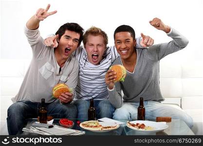 three friends eating while watching television