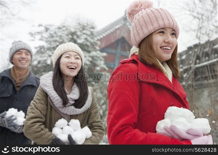 Three friends Holding snow balls in snow in park