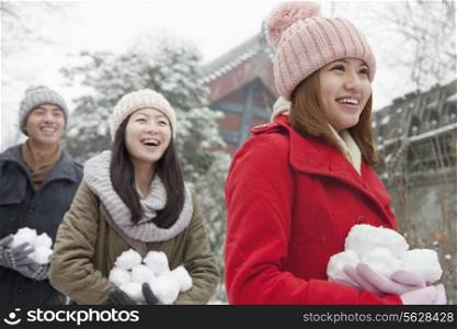 Three friends Holding snow balls in snow in park