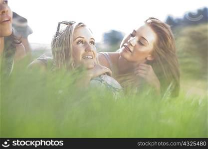 Three friends lying in grass daydreaming