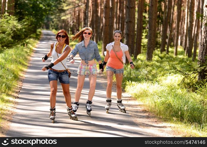 Three friends on in-line skates outdoor on summer countryside road