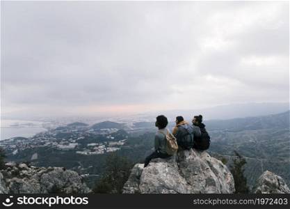 three friends sitting top mountain enjoying scenic view. High resolution photo. three friends sitting top mountain enjoying scenic view. High quality photo