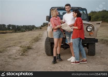 three friends traveling by car checking map 2