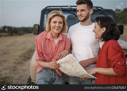 three friends traveling by car checking map
