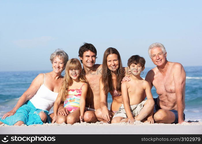 Three Generation Family On Holiday Walking Along Beach