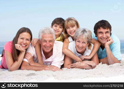 Three Generation Family Relaxing On Beach Holiday