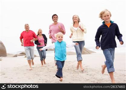 Three Generation Family Running Along Winter Beach Together