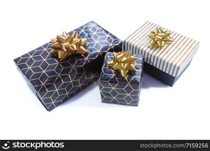 Three gift boxes are black-gold with a geometric pattern and a gold bow and black with a white and gold shiny lid and a gold bow. Isolate on a white background.
