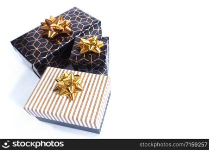 Three gift boxes are black-gold with a geometric pattern and a gold bow and black with a white and gold shiny lid and a gold bow. Isolate on a white background.