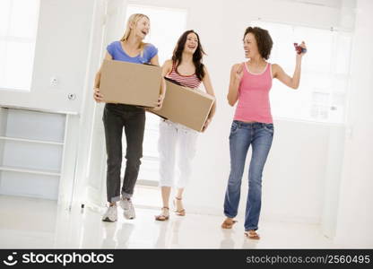 Three girl friends moving into new home smiling