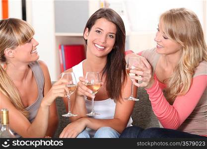 three girlfriends drinking wine together