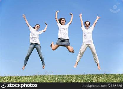 Three girlfriends in white T-shorts jump having waved hands