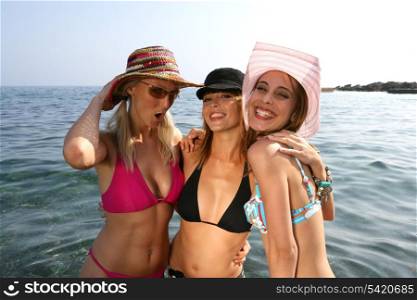 Three girlfriends posing in the sea on holiday
