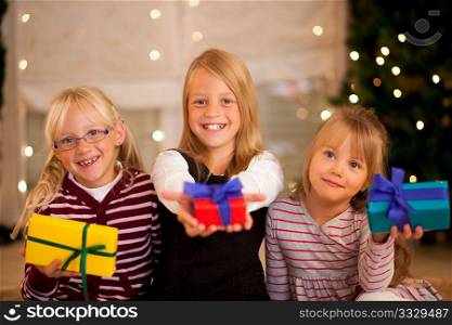 Three Girls in front of a Christmas tree with presents