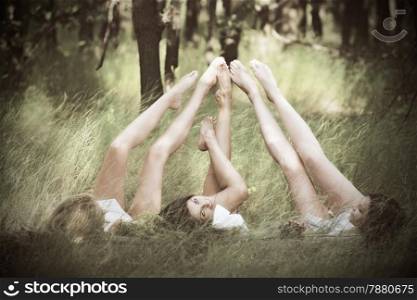 three girls lying on grass