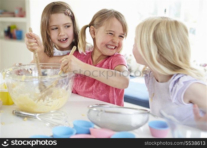 Three Girls Making Cupcakes In Kitchen