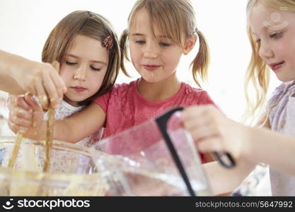 Three Girls Making Cupcakes In Kitchen