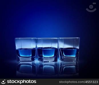 Three glasses of blue liquid. Image of three glasses of blue liquid
