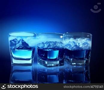 Three glasses of blue liquid. Three glasses of blue liquid with mountain illustration in