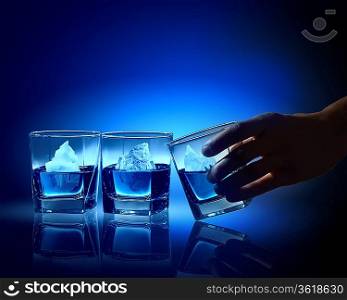 Three glasses of blue liquid with icebergs in