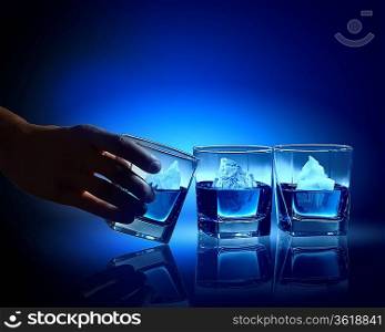 Three glasses of blue liquid with icebergs in