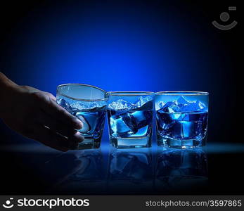 Three glasses of blue liquid with mountain illustration in