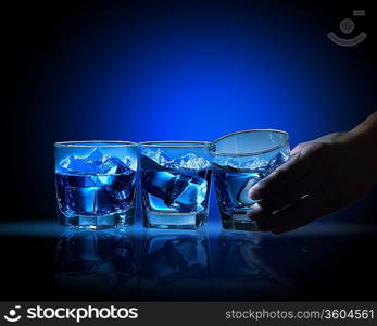 Three glasses of blue liquid with mountain illustration in